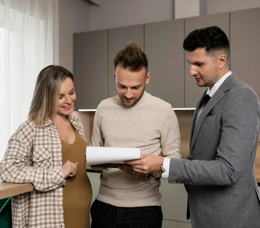 Three people reviewing a document together in a modern office setting